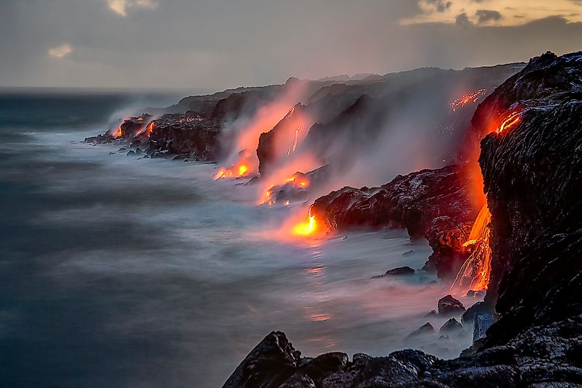 View of lava spilling into the ocean over a cliff on the Big Island, Hawaii