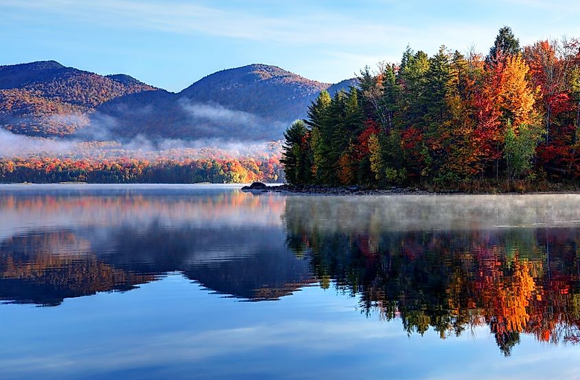 A view of the lake and trees backdropped by the mountains in the Green Mountain National Forest